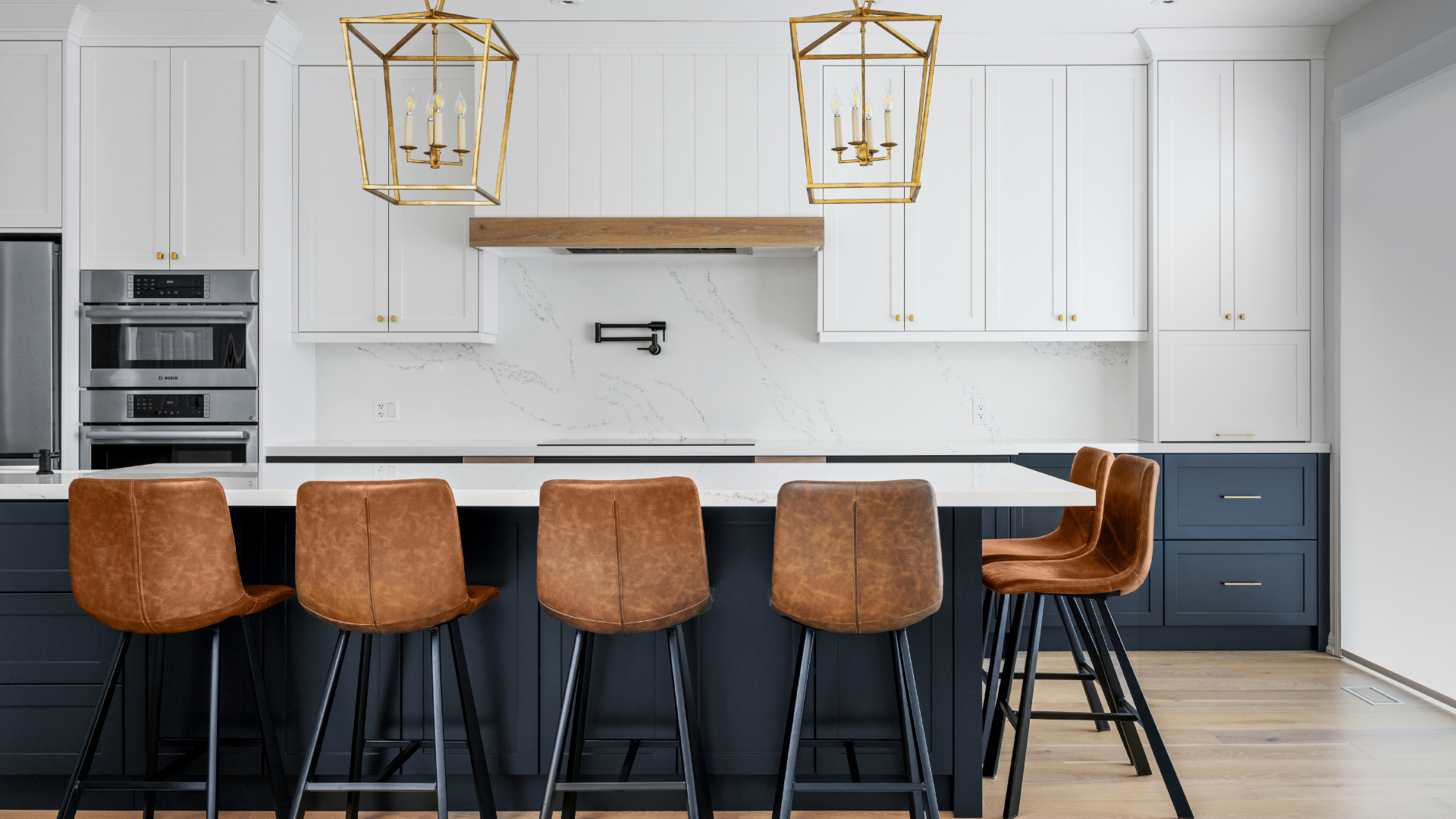 Boughton Crescent kitchen with a navy island, brass lanterns and leather stools