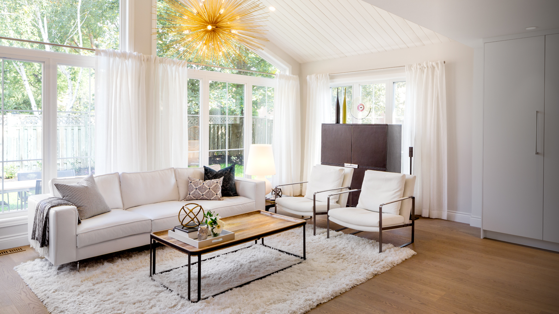 Raymerville Drive living room with a vaulted ceiling and starburst chandelier