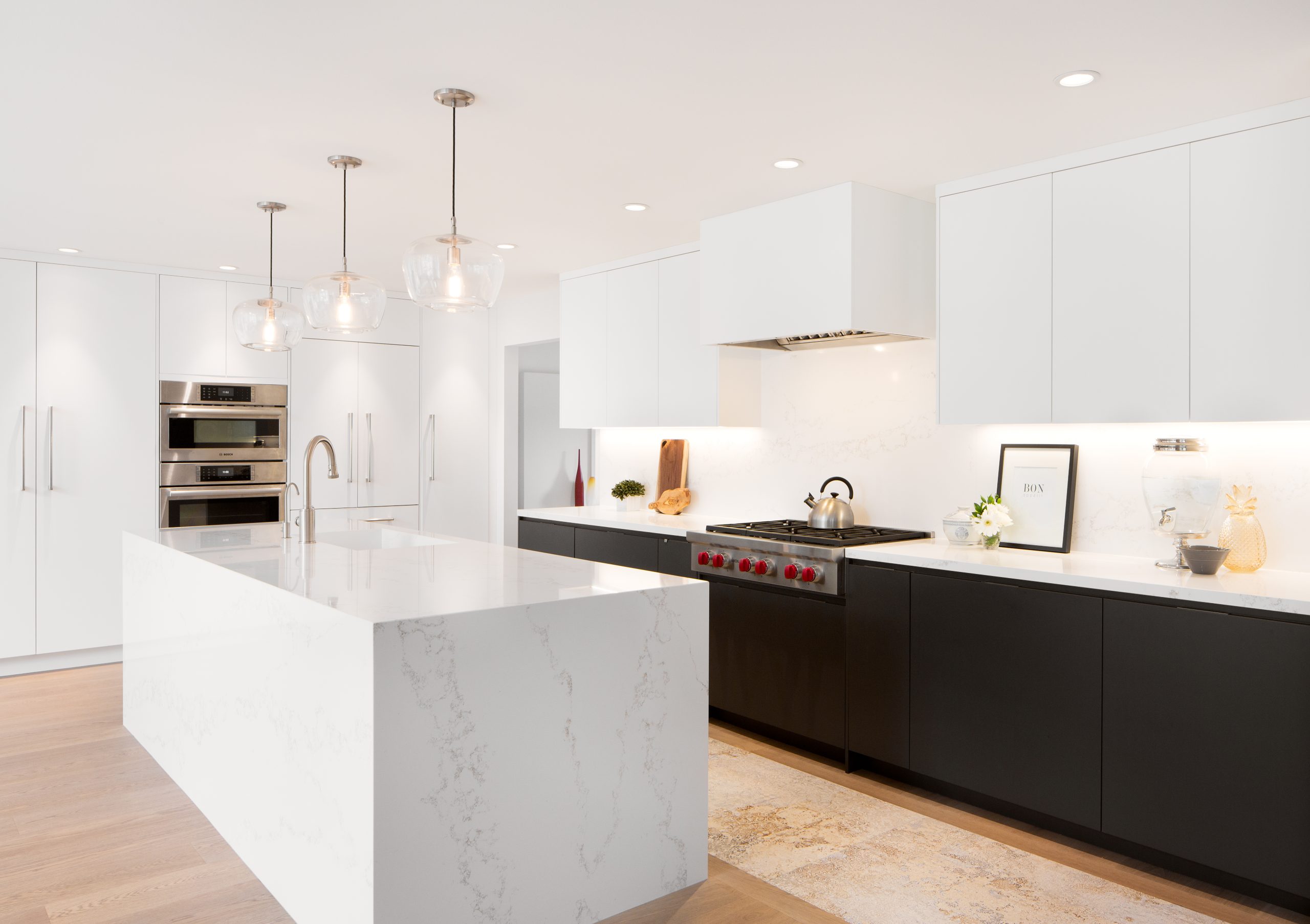 Raymerville Drive kitchen with a white waterfall island and integrated appliances